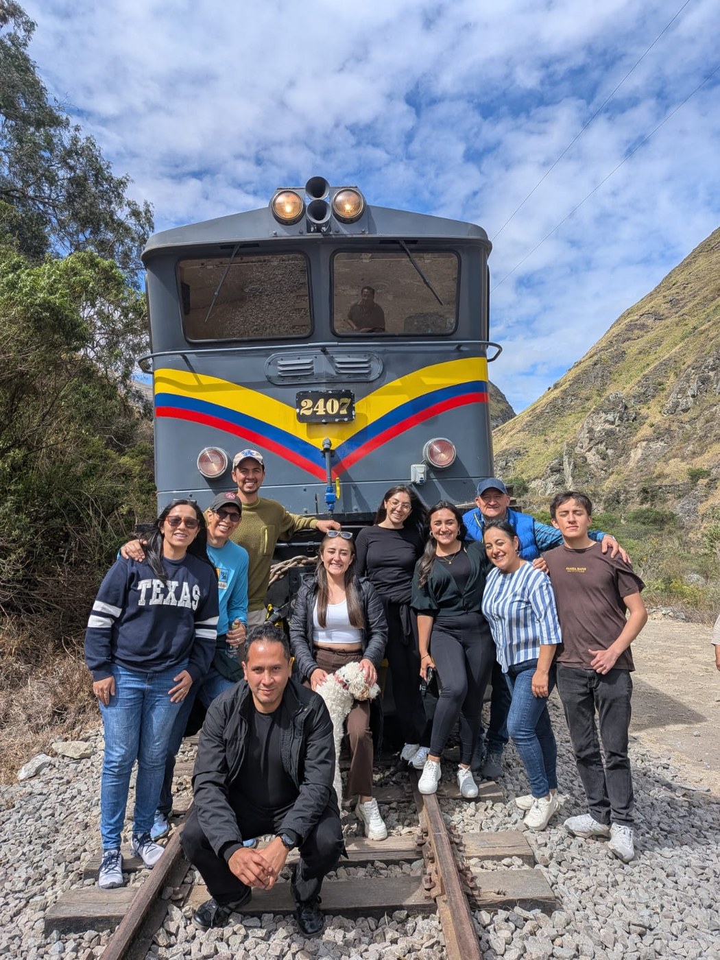 Grupo de viajeros frente a la locomotora 2407, Tren Nariz del Diablo, Ecuador